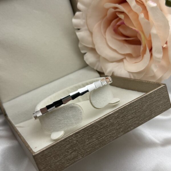 Upečatljiva masivna halka srebrna narukvica sa Iconic T motivom optočenim cirkonima na bijelom satenu - Zlatara Čehajjić