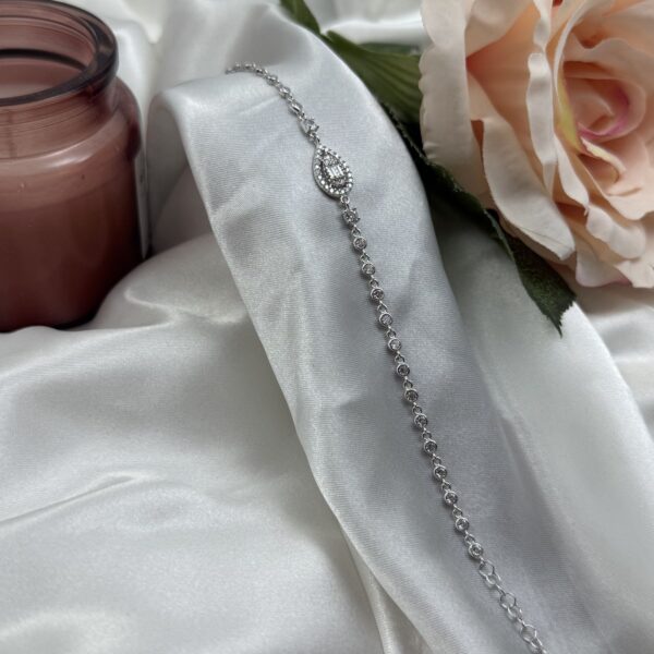 Srebrna narukvica sa centralnim cirkonom u obliku suze na bijeloj satenskoj podlozi